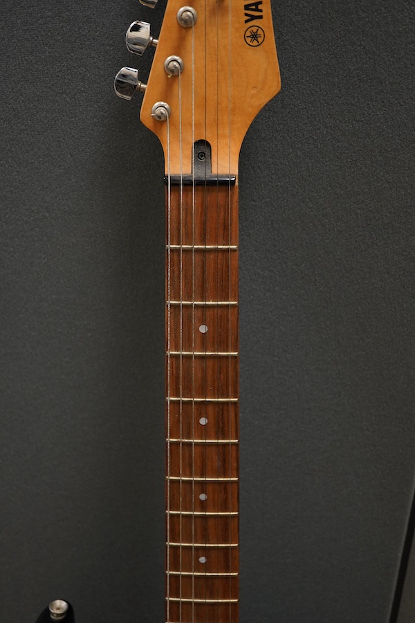 A Yamaha ERG121 electric guitar in black finish, with a soft gig case